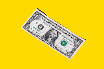 Closeup of one dollar paper currency isolated on yellow background with copy space
