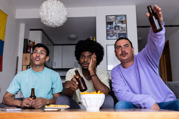 Male fans with beer watching match at home