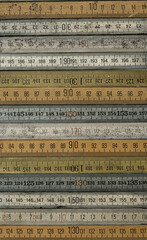 A variety of vintage wooden folding rulers arranged