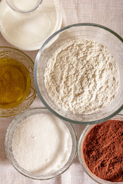 Top view of Variety of baking ingredients in clear glass bowls placed on table