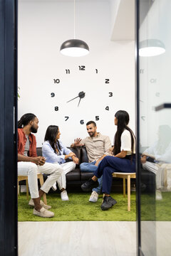 Multiracial colleagues discussing in lobby at office