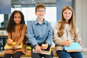 Multiracial schoolchildren having lunch at the desk during a break in school