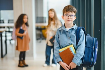 Schoolboy with schoolbag and books in the school. Back to school