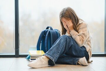 Bullying, discrimination or stress concept. Sad teenager crying in school