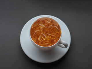 white cup filled with vitamins on a white saucer