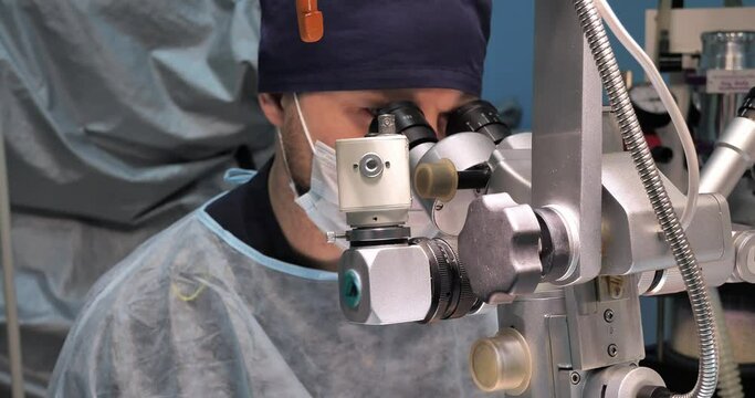 A veterinary ophthalmologist operates on a pet's eye using a microscope. A pet with an eye disease undergoing surgery in a veterinary clinic. Veterinary ophthalmic surgery concept.