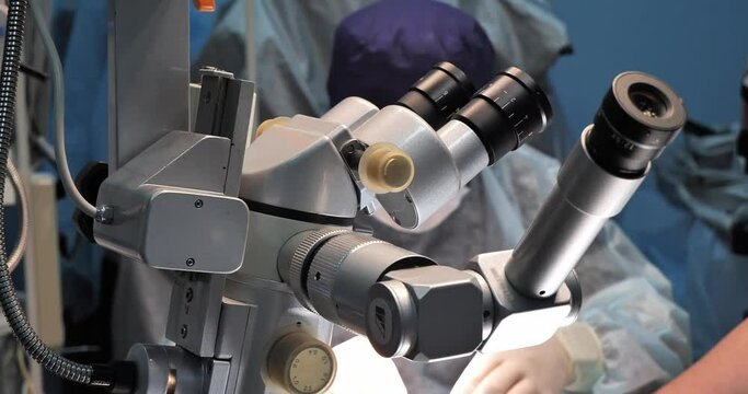 A major operation to restore vision in a pet under an ophthalmological microscope. A veterinary ophthalmologist surgeon completes an operation on an animal's eye and sutures the wound.