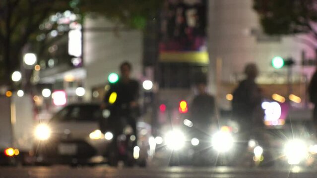 SHIBUYA, TOKYO, JAPAN - NOV 2023 : View of street traffic at night. Many cars, bus, taxi and bike passing by on the road. Japanese transportation and traffic concept video. Out focus shot.