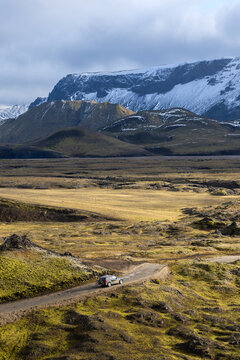 From above of a lone suv on road in Icelandic Highlands in Thorsmork against mountains on cloudy day