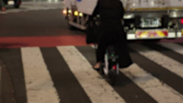 TOKYO, JAPAN - NOV 2023 : View of people riding on Electric Assist Bicycle Sharing Service at the street. Blurred shot.