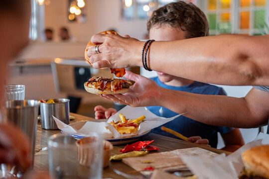 Anonymous person serving burger to boy