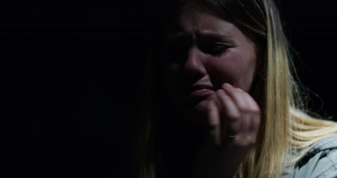Woman, trauma and kidnapping victim crying with stress, fear and danger for terrorism and horror. Scared girl, ransom and young female hostage in crisis, prison and frustrated for help in dark room.