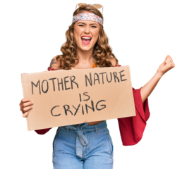 Young blonde girl wearing hippie style holding mother nature is crying protest cardboard banner screaming proud, celebrating victory and success very excited with raised arms