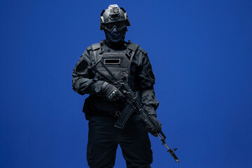 Soldier in black uniforms with weapon in studio. Concept Military warrior army tactical force to fight crime in city