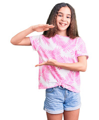 Cute hispanic child girl wearing casual clothes gesturing with hands showing big and large size sign, measure symbol. smiling looking at the camera. measuring concept.