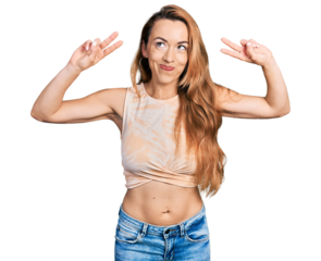 Young caucasian woman doing victory sign and peace gesture smiling looking to the side and staring away thinking.