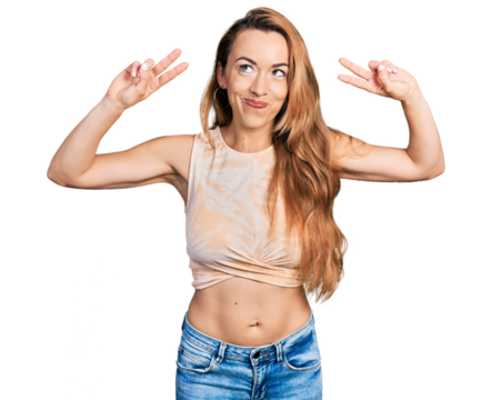 Young caucasian woman doing victory sign and peace gesture smiling looking to the side and staring away thinking. - Powered by Adobe