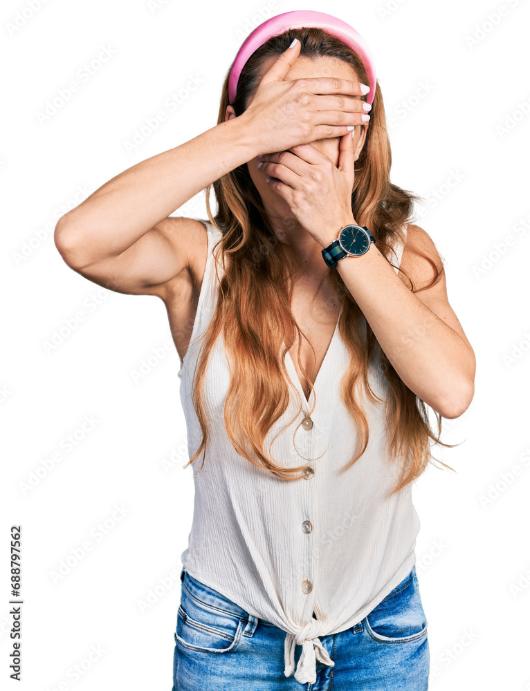 Poster young caucasian woman wearing casual style with sleeveless shirt covering eyes and mouth with hands,