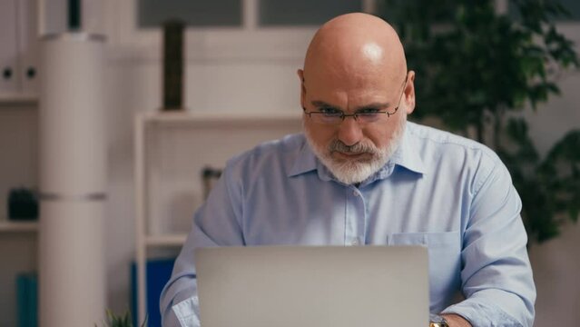 Businessman feeling lower back pain while working on laptop, sedentary lifestyle