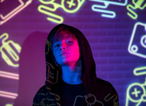 Youth in hoodie with neon graffiti background
