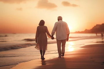  A man and a woman walking on a beach at sunset. Ideal for travel and romance themes © Fotograf