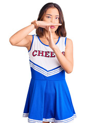 Young beautiful chinese girl wearing cheerleader uniform doing time out gesture with hands, frustrated and serious face