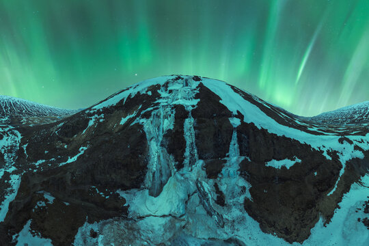 Majestic northern lights over snowy Icelandic mountains