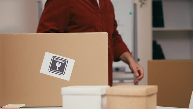 Sloppy worker throwing box with fragile items on desk, damaged goods, delivery