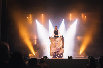 Magician performing disappearing trick on stage