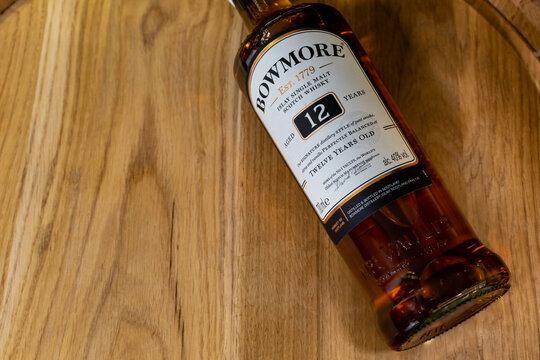 Bottle of single malt scotch whisky Bowmore 12 years aged on wooden cask close-up. Ukraine, Zhytomyr, December, 5, 2023