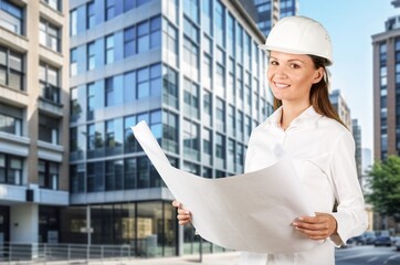 Engineer worker woman holding plans at construction site