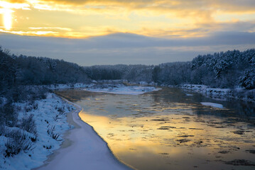 beautiful frosted trees and ducks in the river at evening sunset in winter