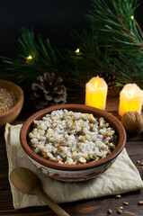 Kutya, a traditional Christmas Ukrainian dish of wheat groats on the table for Christmas or the old new year. Boiled porridge with walnuts, raisins, poppy seeds and honey. Rustic style.