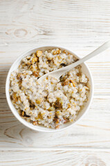 Kutya, a traditional Ukrainian Christmas dish made of wheat groats on the table for Christmas or the old New Year. Boiled porridge with walnuts, raisins, poppy seeds and honey in a white bowl.
