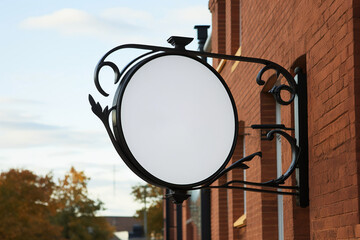 Company branding in focus with a round white sign mockup in a country city