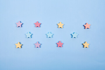 Multicolor wooden stars shapes symbol label form isolated on the bright solid fond plain bright...