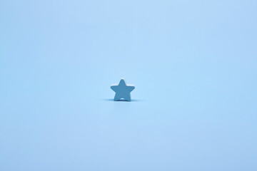 One alone blue wooden star shape symbol label form isolated on the bright solid fond plain bright...