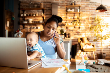 Business mother working from home making phone call holding baby boy