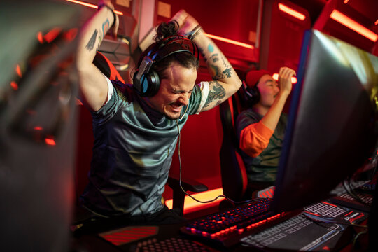 Professional male gamer swinging arms in air during tournament