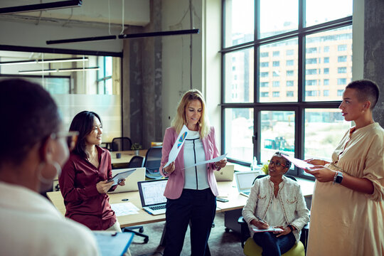 Diverse group of businesswomen collaborating on a new project in modern office