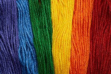 Colorful embroidery threads arranged in rainbow pattern resembling LGBT pride flag