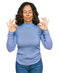 Middle age hispanic woman wearing casual clothes relax and smiling with eyes closed doing meditation gesture with fingers. yoga concept.
