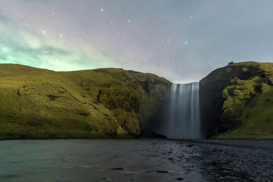 Majestic Skogafoss waterfall under a starlit night sky in Iceland