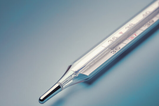 mercury thermometer close-up on a blue background