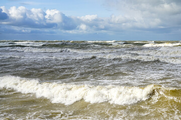 Stormy weather seascape, big waves with foam, low dark cumulus clouds, stormy sea view