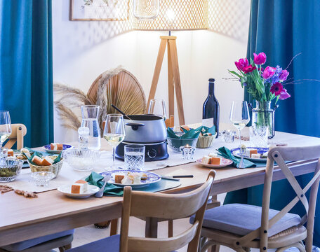 Elegant dinner table setup with fondue pot and flowers