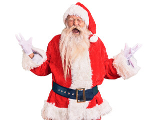 Old senior man with grey hair and long beard wearing traditional santa claus costume celebrating mad and crazy for success with arms raised and closed eyes screaming excited. winner concept