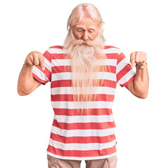 Old senior man with grey hair and long beard wearing striped tshirt pointing down with fingers...
