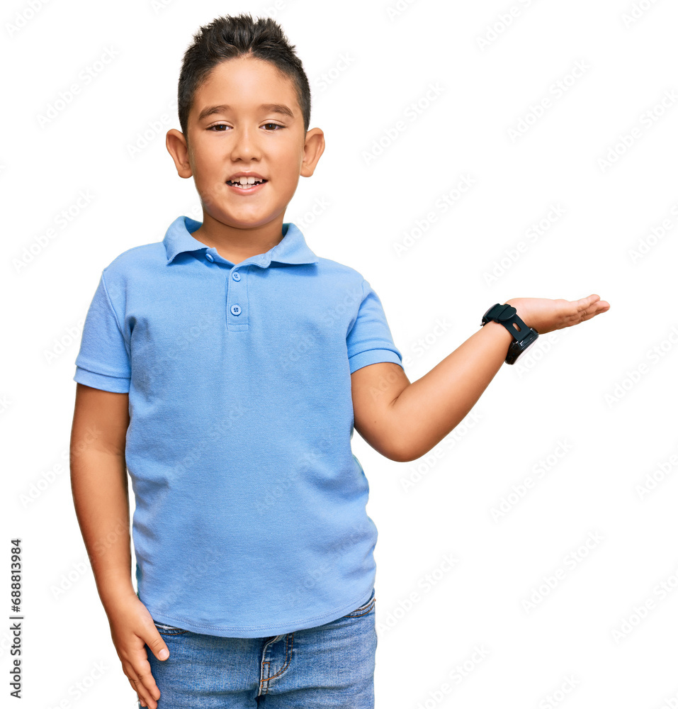 Wall mural little boy hispanic kid wearing casual clothes smiling cheerful presenting and pointing with palm of