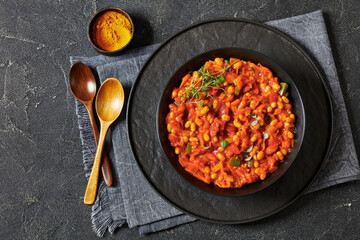 chakalaka, spicy tomato bean relish in black bowl